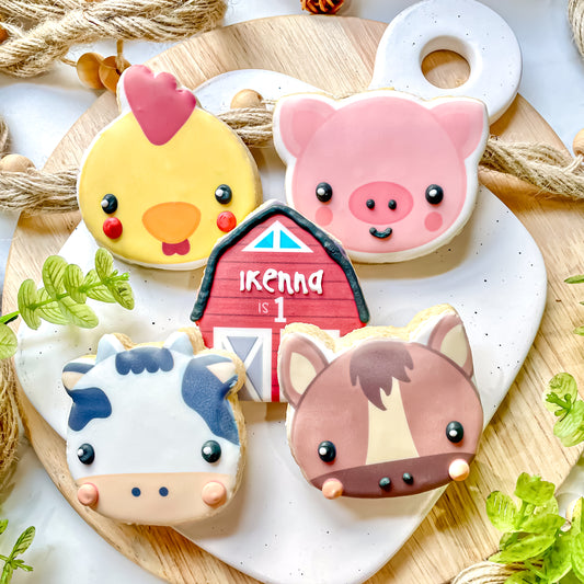 sugar cookies decorated with farm animals like a pig, cow, horse, and chicken