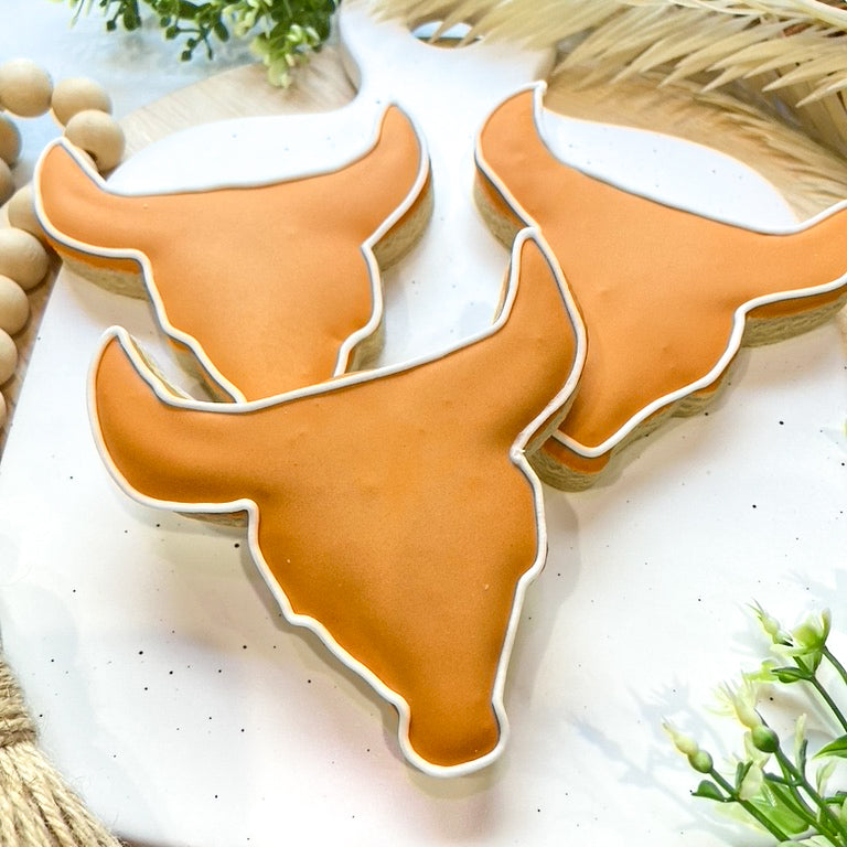 A set of Texas Longhorn-themed graduation cookies, featuring Hook ‘Em Horns, the Texas logo, and customizable graduation messages.