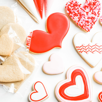 Heart-shaped cookies with red and white icing on a white surface