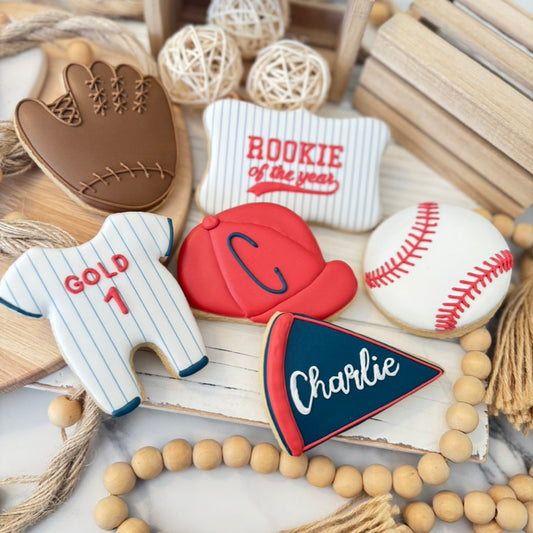 baseball themed sugar cookies decorated with a baseball glove, bat, cap, onesie, and ball