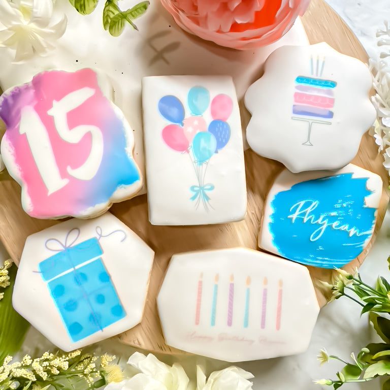 sugar cookies decorated with the number 15, balloons, a gift, and candles