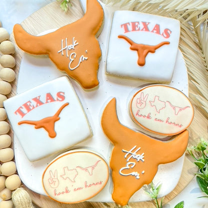 University of Texas graduation cookies featuring the Longhorn logo, cusatom text, and the iconic Hook 'Em Horns hand symbol.

